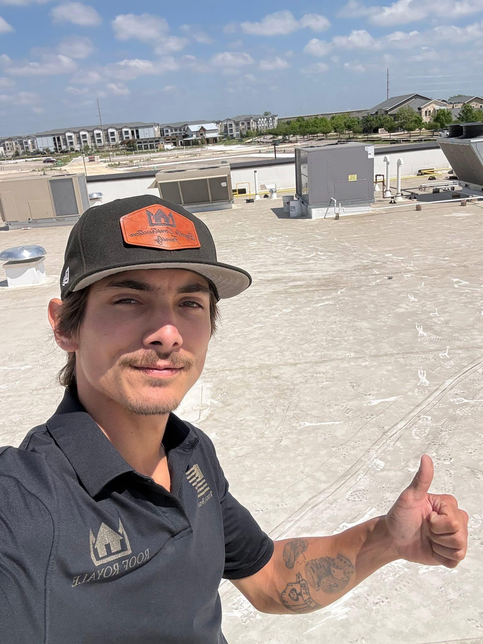 Roof Royale team member giving a thumbs-up during a commercial flat roof inspection