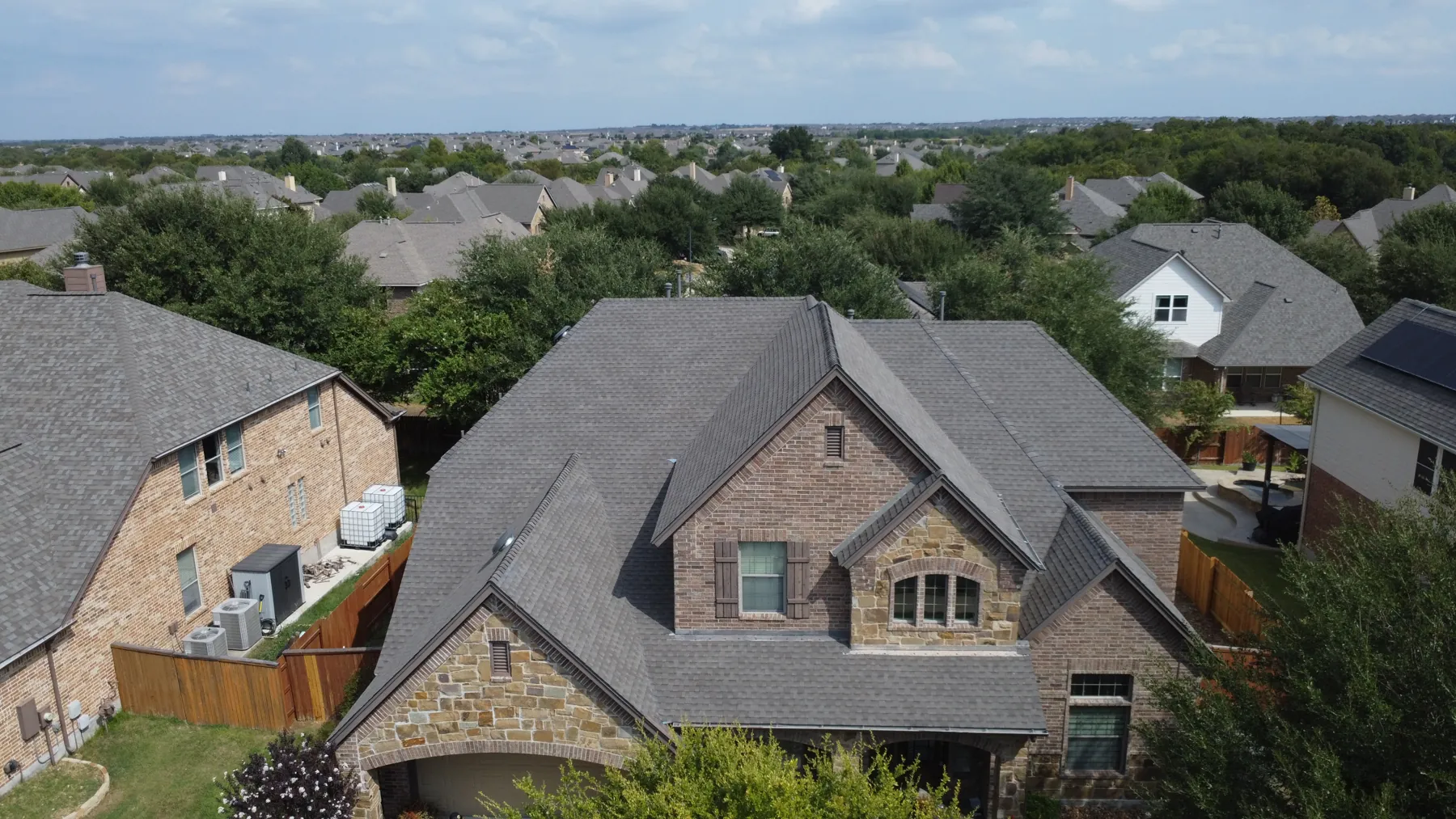 Completed roof replacement in the Paloma Lake neighborhood of Round Rock, Texas, GAF Timberline Natural Shadow shingles in Weatherwood, photographed from above