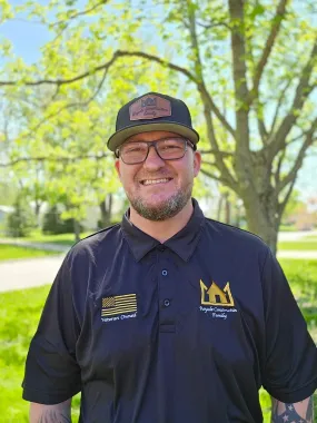 Chris P. smiling outdoors in a Roof Royale polo