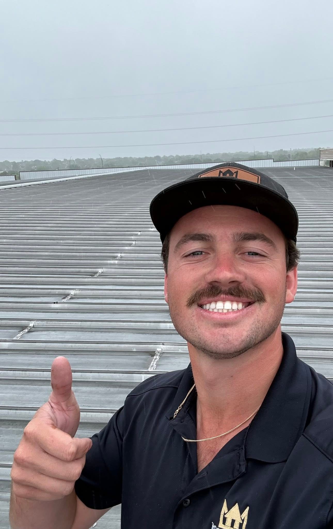Jacob M. giving a thumbs-up on a metal roof